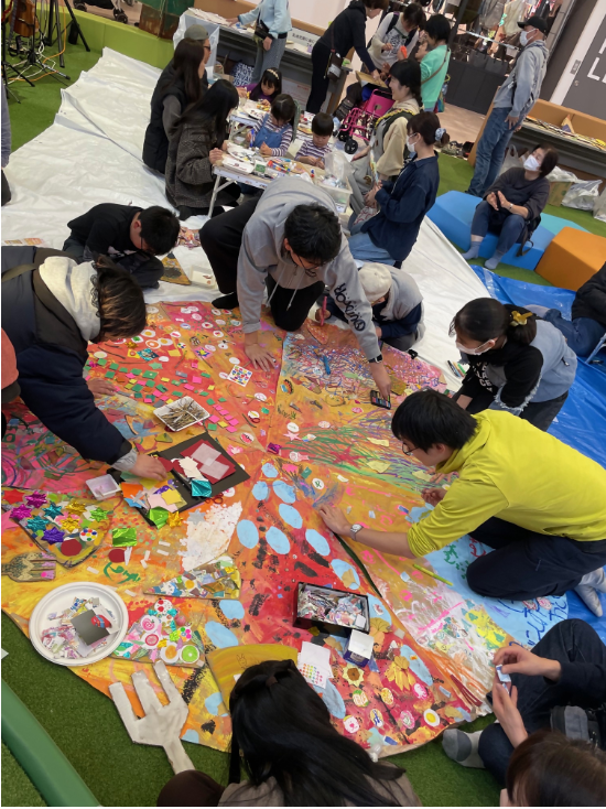 アートワークショップのイメージ（大人数で作業中）