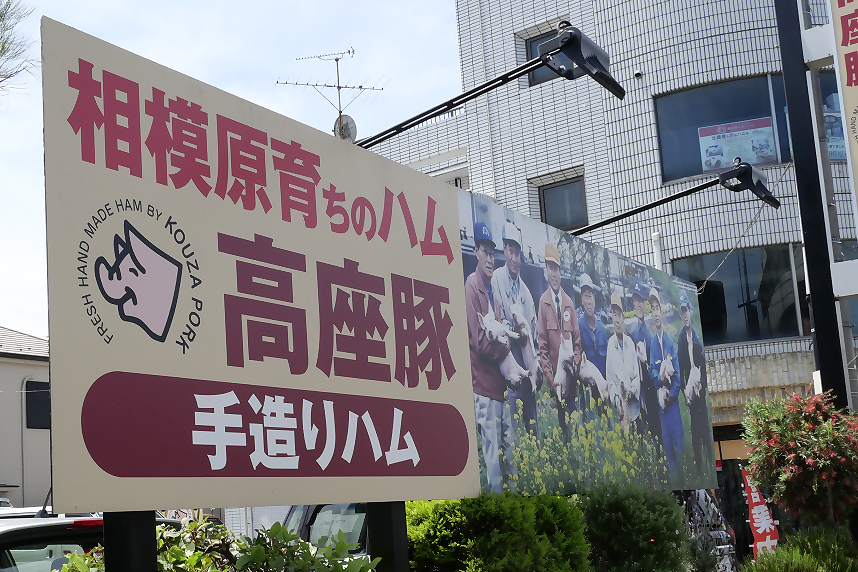 駐車場にある高座豚手造りハムの看板写真