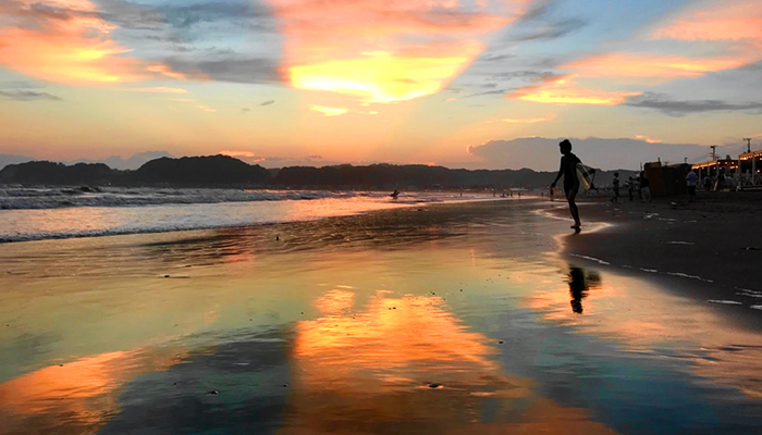 Walking along the beach while watching sunset in the early evening.3