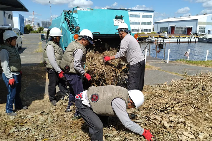 数人で草刈集めをしている写真